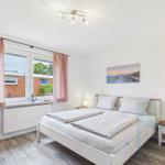 Schlafzimmer mit Doppelbett, Fenster und Nachttisch