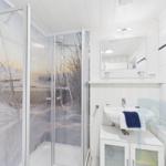 Badezimmer mit Dusche, Waschbecken und Spiegel