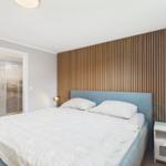 Schlafzimmer mit Doppelbett, Holzwand und Nachttisch