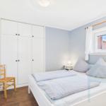 Bedroom with bed, wardrobe, and window