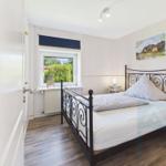 Bedroom with bed, window, and wall picture.