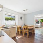 Kitchen with dining table, red fridge, and view to terrace.