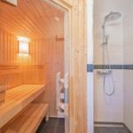 Sauna mit Holzbank und Dusche mit Duschbrause