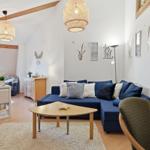 Living room with blue sofa, wooden table, and wall decor.
