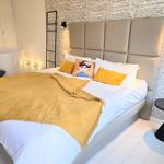 Schlafzimmer mit Bett, Badewanne und Wand mit Texten.
