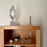 Holzregal mit Skulptur, Kerze und Gläsern auf Regalboden