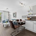 Wohnküche mit Essbereich, Sofa und Terrasse mit Gartenblick.