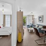 Wohnung mit Schlafzimmer, Wohnbereich und Essbereich. Holzboden und moderne Einrichtung.