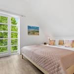 Bedroom with bed, window, and wall art.