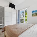 Bedroom with bed, wardrobe, and window to the garden.