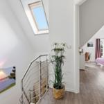 Staircase with skylight and room with bed and window
