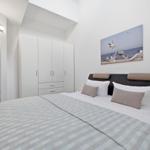 Bedroom with bed, wardrobe, and wall art of seagulls.