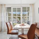 Dining area with brown leather seats and view of balcony