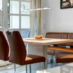 Dining table with brown leather seats and window view
