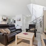Living room with leather sofa, coffee table, and staircase.