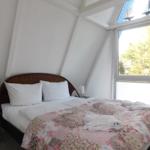 Schlafzimmer mit Bett, Fenster und Deckenbalken