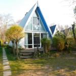 A-frame-Haus mit großem Fenster und Terrasse im Garten