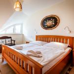 Schlafzimmer mit Holzbett, Fenster und Wandbild