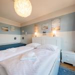 Schlafzimmer mit Doppelbett, Wandbildern und Nachttisch