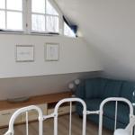 Ein Raum mit einem Sofa, einem Schrank und zwei Bildern an der Wand.