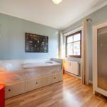 Ein Schlafzimmer mit Bett, Schrank, Fenster und Wandbild.