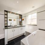 Badezimmer mit Dusche, Badewanne und Waschbecken mit Spiegel