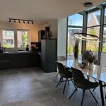 Moderne Küche mit Essbereich und großem Fensterblick auf die Straße.
