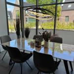 Esszimmer mit Tisch, Stühlen und großem Fensterblick auf Garten