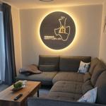 Wohnzimmer mit Sofa, Tisch und Wanddekoration.