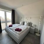 Schlafzimmer mit Doppelbett, Fenster und Kleiderständer.
