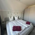 Schlafzimmer mit Doppelbett, Nachttischen und Kleiderschrank. Auf dem Bett liegen Handtücher.