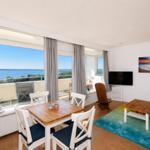 Apartment with dining area and balcony view of water