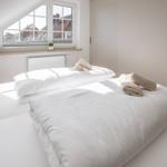 Schlafzimmer mit Dachfenster, Bett und Handtüchern