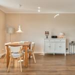 Esszimmer mit Holztisch, Stühlen, Sideboard und Fenster.