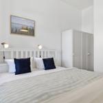 Bedroom with bed, wardrobe, and wall picture.