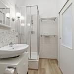 Badezimmer mit Dusche, Waschbecken und Spiegel