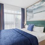 Schlafzimmer mit Bett, Fenster, TV und Wandbild