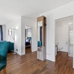 Wohnung mit Wohnbereich, Schlafzimmer und Bad. Holzdielenboden und Teppichboden.