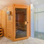 Dusche mit Glaswand, Sauna und Waschbecken mit Spiegel