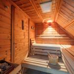 Sauna mit Holzbank, Eimer und Steine an der Wand