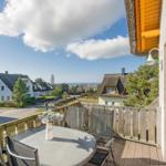 Terrasse mit Tisch und Stühlen. Blick auf traditionelle Häuser und Landschaft.