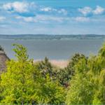 Haus mit Strohdach, Blick auf See und Wald