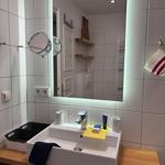 Bathroom with sink, mirror, and wooden countertop.