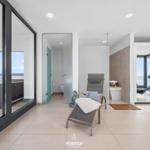 Wohnbereich mit Blick aufs Meer, Liege, Fitnessgeräte und Badzimmer.