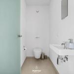 Badezimmer mit Toilette, Waschbecken und Spiegel