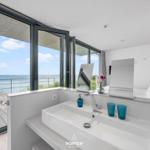 Badezimmer mit Blick aufs Meer und integriertem Waschbecken