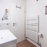 Bathroom with sink, heater, and wall decor