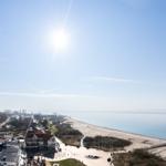 Panoramic view of beach and sea under bright sunshine.