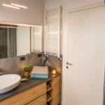 Badezimmer mit Waschbecken, Dusche und Handtuchheizung.