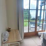 Schreibtisch mit Ventilator und Blick auf Terrasse